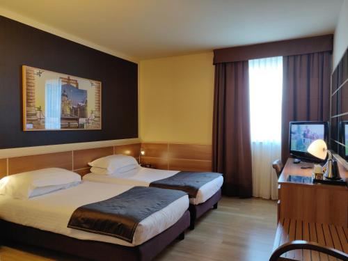a hotel room with two beds and a television at Best Western Hotel Tre Torri in Altavilla Vicentina