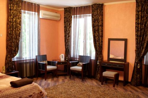 a bedroom with a bed and a desk and a mirror at Totem Hotel in Shymkent