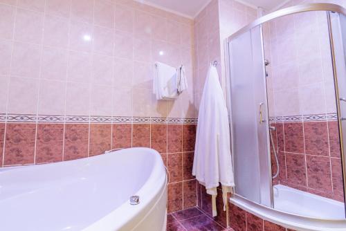 a bathroom with a shower and a white tub at Hotel Complex Vizit in Kozin