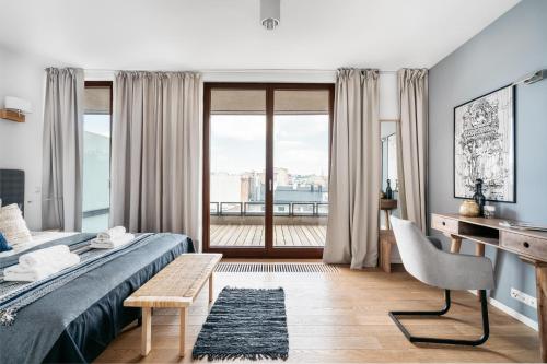 a bedroom with a bed and a desk and a window at Penthouse Uptown by LoftAffair in Krakow