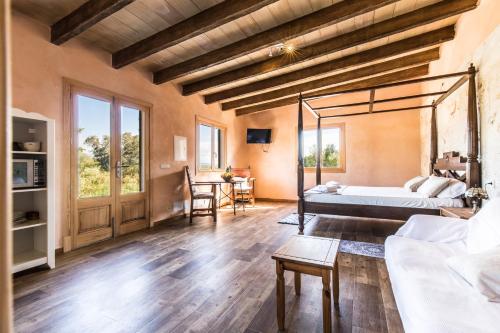 a bedroom with a bed and a living room at Finca Agroturismo Sa Cova den Borino in Campos