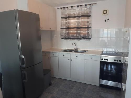 a kitchen with a sink and a refrigerator at Apartments Sara in Tisno