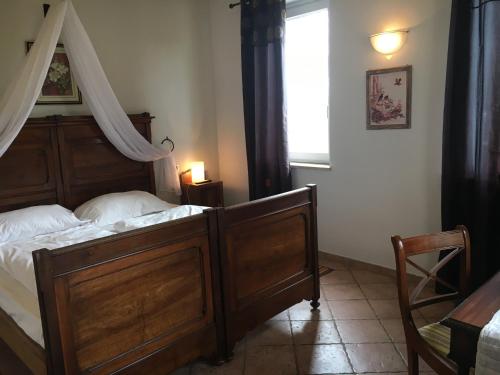 a bedroom with a wooden bed and a window at Cascina Vignole in Montafia