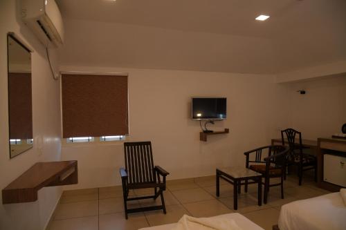 a room with chairs and a tv on the wall at RAMAS GARDEN in Trivandrum