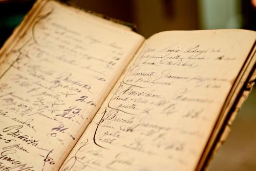 an open book with handwriting on the pages at Hotel san Vitale in Bormio