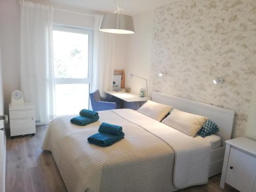 Heaven Apartament في بوغورزيلكا: غرفة نوم مع اثنين من المناشف الزرقاء على سرير