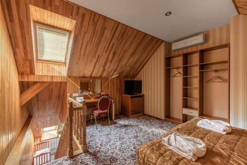 a bedroom with a bed and a desk with a computer at Status Hotel in Lviv