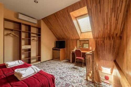 a bedroom with a bed and a desk and a window at Status Hotel in Lviv