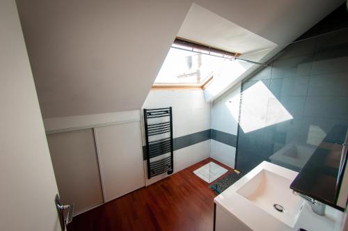 un baño en el ático con lavabo y ventana en Le Massilia comble, en Vichy