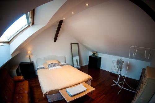 een slaapkamer met een bed in een kamer met een zolder bij Le Massilia comble in Vichy