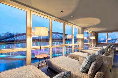 a large room with large windows with a view of a stadium at Das König Ludwig Inspiration SPA in Schwangau