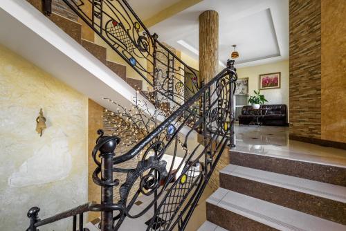 a spiral staircase with a wrought iron railing at Status Hotel in Lviv