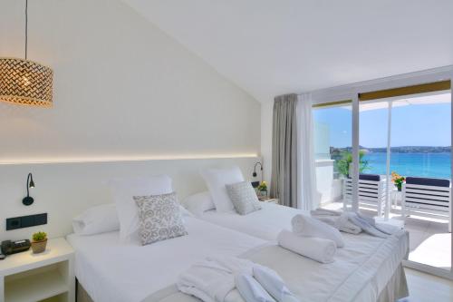 
a hotel room with two beds and a large window at Paguera Treff Boutique Hotel in Paguera
