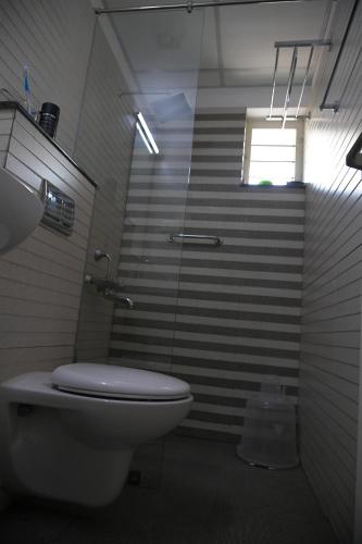 a bathroom with a toilet and a window and stairs at RAMAS GARDEN in Trivandrum