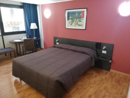 a bedroom with a bed and a red wall at Ibis Styles Palermo Cristal in Palermo
