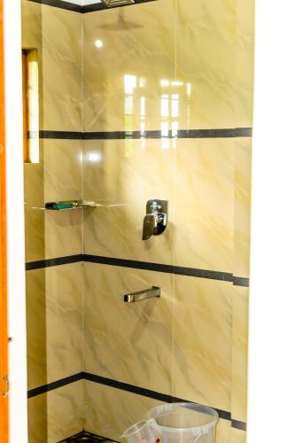 a shower with a glass door in a bathroom at Nandana's Residency Munnar - A 4BHK Homestay for Indian Families in Munnar
