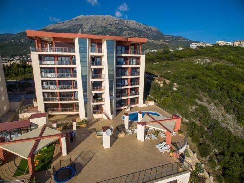 an aerial view of a building with a mountain in the background at Apartments Sunny Marina in Dobra Voda