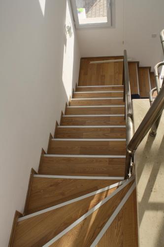 a staircase in a building with wooden floors and a window at Suluca Homes in Kérynia