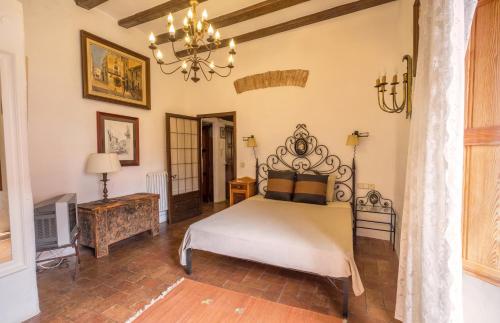 a bedroom with a bed and a chandelier at Can Felip Apartments in Palafrugell