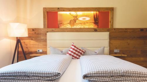 a bedroom with two beds and a picture of a deer at Landgasthof & Hotel beim Lipp in Roßhaupten