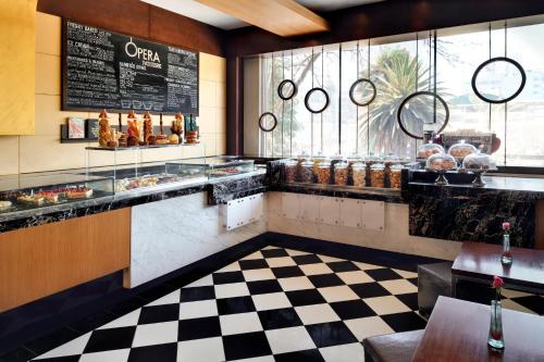 a restaurant with a checkered floor and a counter with food at Sankara Nairobi, Autograph Collection in Nairobi