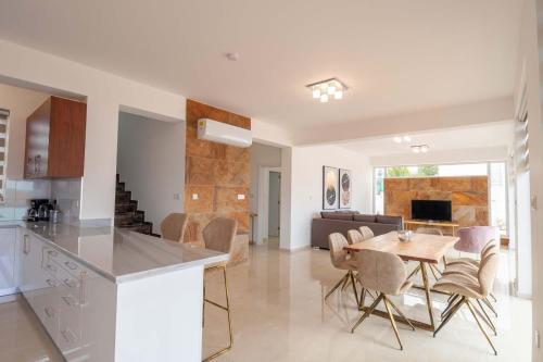 een keuken en een woonkamer met een tafel en stoelen bij Coral Elite Residences in Coral Bay