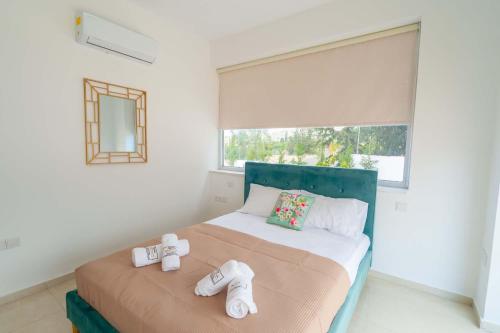 a bedroom with a bed with two towels on it at Coral Elite Residences in Coral Bay