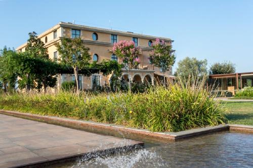 a building with a pond in front of a building at Casa Anamaria Hotel in Ollers