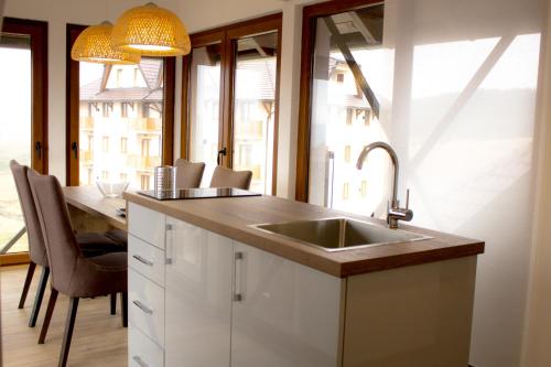 a kitchen with a sink and a table with chairs at Zlatibor Hills in Zlatibor