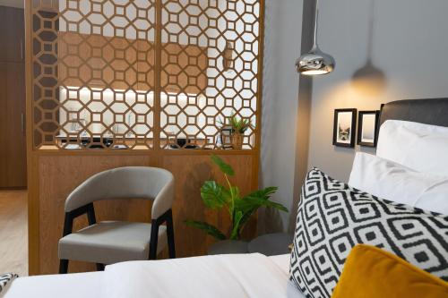 a bedroom with a bed and a chair next to a counter at F & B Collection - Seaview MiniLux in Thessaloniki