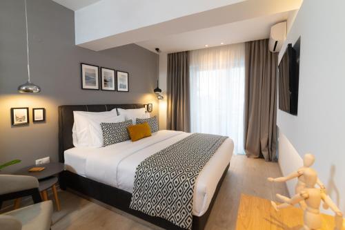 a bedroom with a bed and a room with a tv at F & B Collection - Seaview MiniLux in Thessaloniki