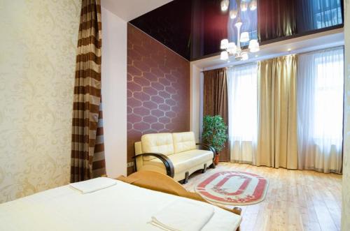 a room with two beds and a chair and a window at LEOGRAND Apartments on Doroshenka 34 in Lviv