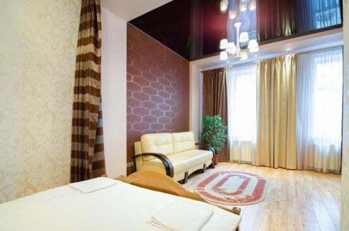 リヴィウにあるLEOGRAND Apartments on Doroshenka 34のベッド2台、椅子、窓が備わる客室です。