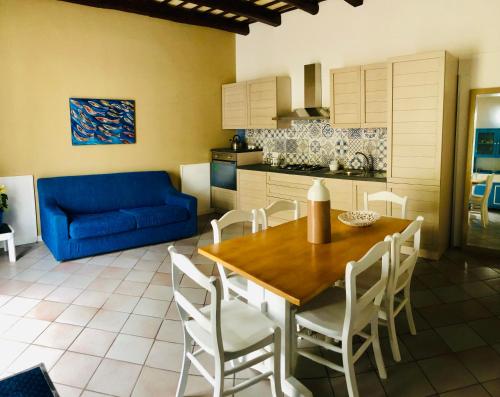 una cucina e una sala da pranzo con tavolo e divano blu di Asmara 10 a Trapani