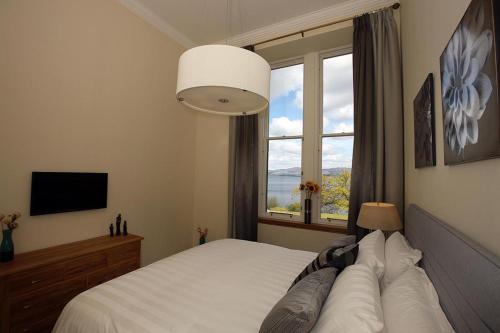 sypialnia z białym łóżkiem i oknem w obiekcie 4 Lomond Castle w mieście Balloch