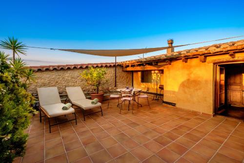 a patio with chairs and a table and a patio umbrella at Can Felip Apartments in Palafrugell