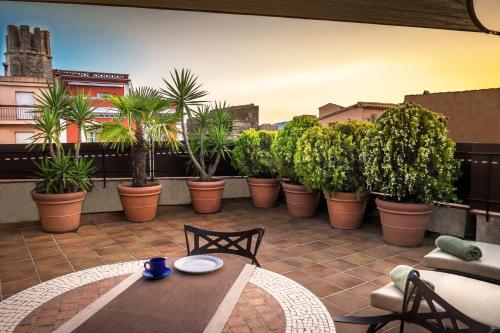 a balcony with a table and chairs and potted plants at Can Felip Apartments in Palafrugell