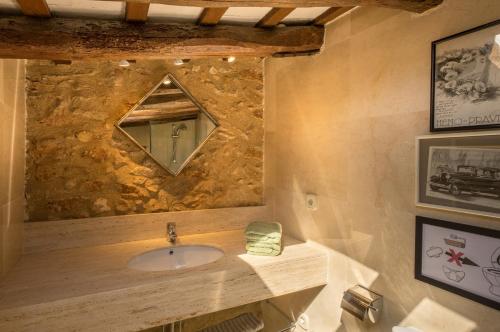 a bathroom with a sink and a stone wall at Can Felip Apartments in Palafrugell