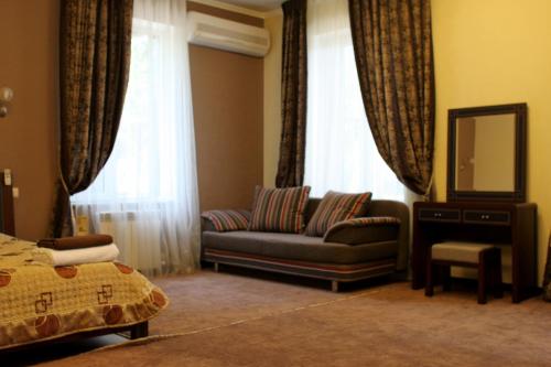 a living room with a couch and a mirror at Totem Hotel in Shymkent