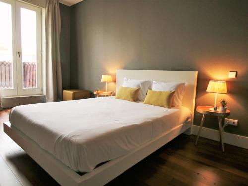 a bedroom with a large white bed with yellow pillows at ALIADOS by YoursPorto in Porto