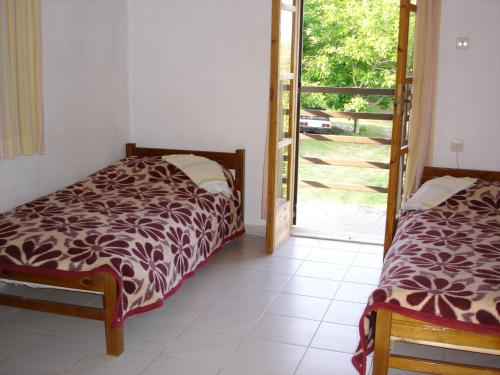a bedroom with two beds and a sliding glass door at Villa Mina in Potistika