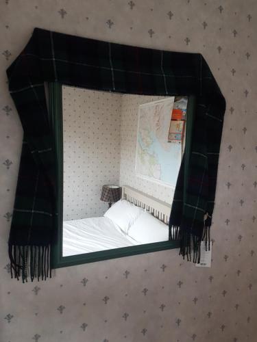 a mirror on a wall with a bed in it at Ceum Thairis in Carbost