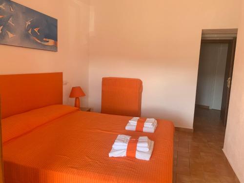 a bedroom with an orange bed with two towels on it at Locanda FarOrientale in Santa Lucia