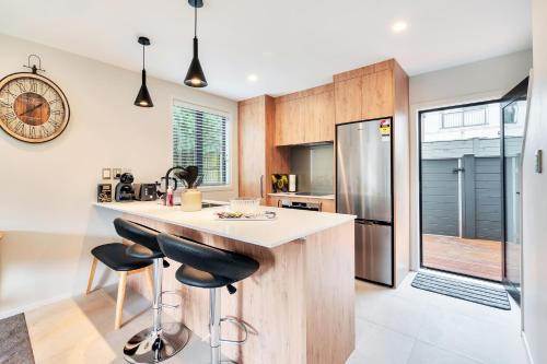 a kitchen with a counter and a refrigerator at Greenwich Townhouse with Parking and Air-Con in Auckland