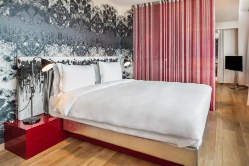 a bedroom with a large white bed with a red wall at Radisson Collection Hotel, Royal Mile Edinburgh in Edinburgh