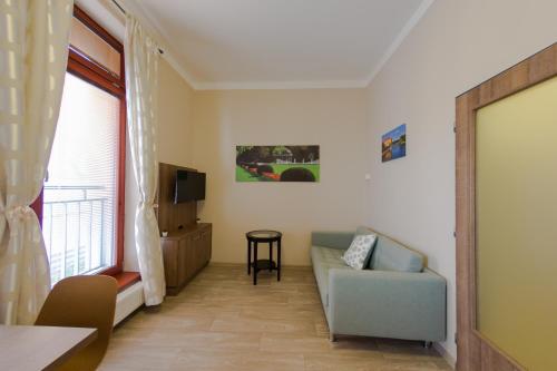 a living room with a couch and a window at Penzion Apartmány Resident in Poděbrady