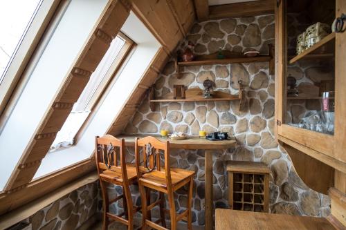 a small table and chairs in a room with a stone wall at Apartamenty Pod Dachem w Centrum APARTZAKOP in Zakopane