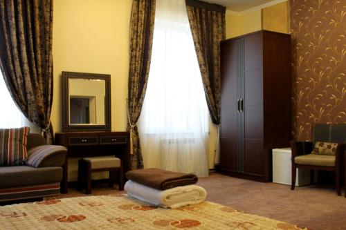 a living room with a window and a mirror at Totem Hotel in Shymkent