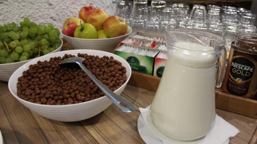 a table with bowls of food and a glass of milk at Resort Big House Plitvička jezera in Ličko Petrovo Selo