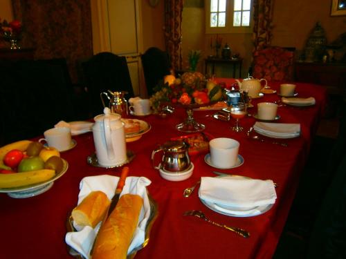 une table avec un tissu de table rouge et de la nourriture dans l'établissement Château de La Sémondière, à Brécey